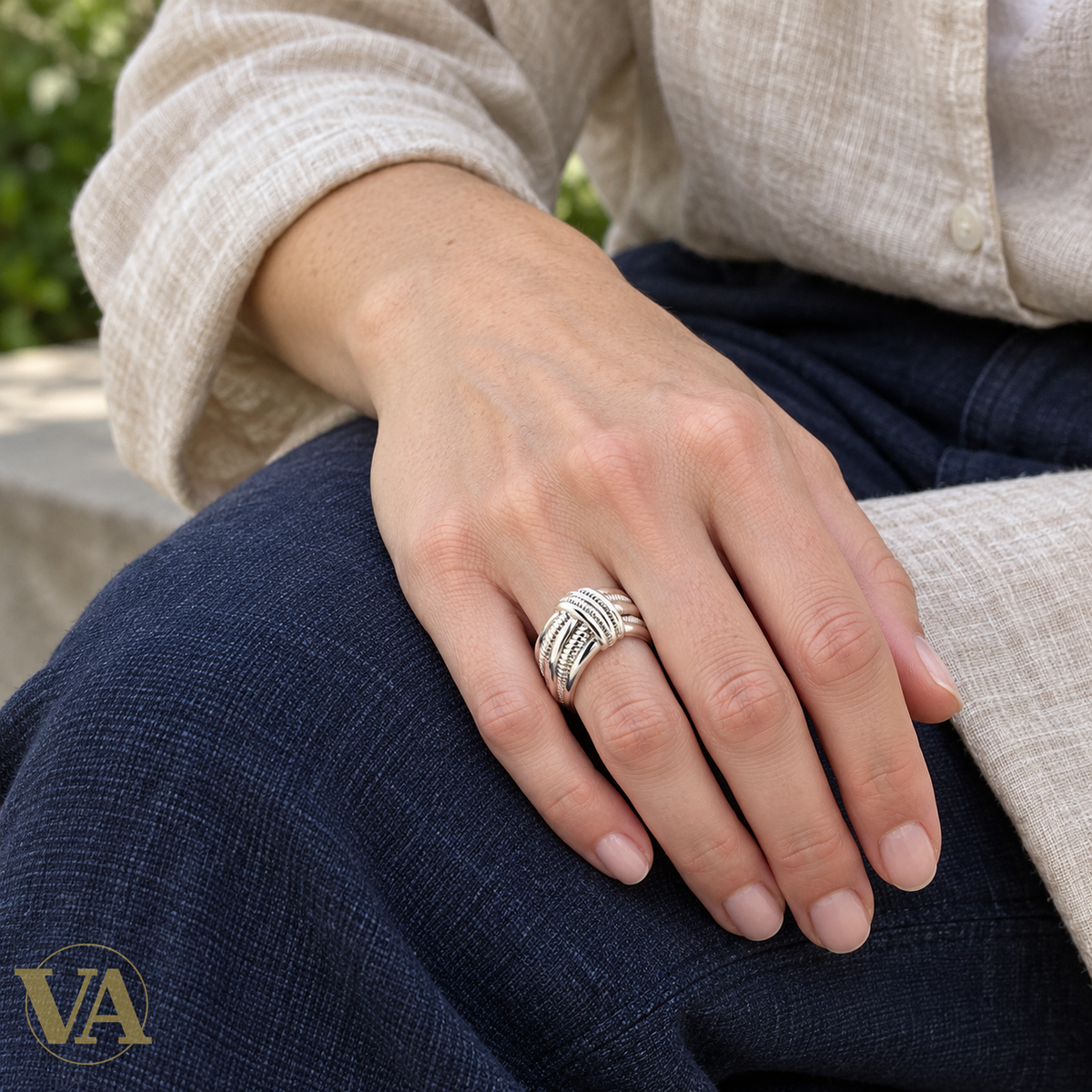 Bague argent rhodié rubans croisés cannelés portée sur une main au repos