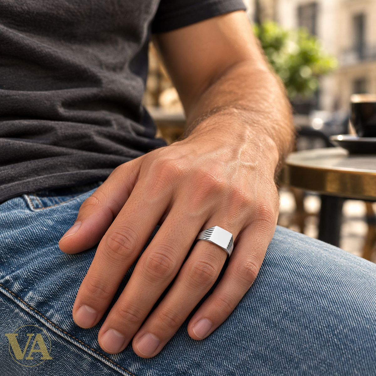 Chevalière homme argent 925 rhodié, plateau rectangulaire et côtés striés — portée avec un t-shirt et un jean, gros plan sur la main