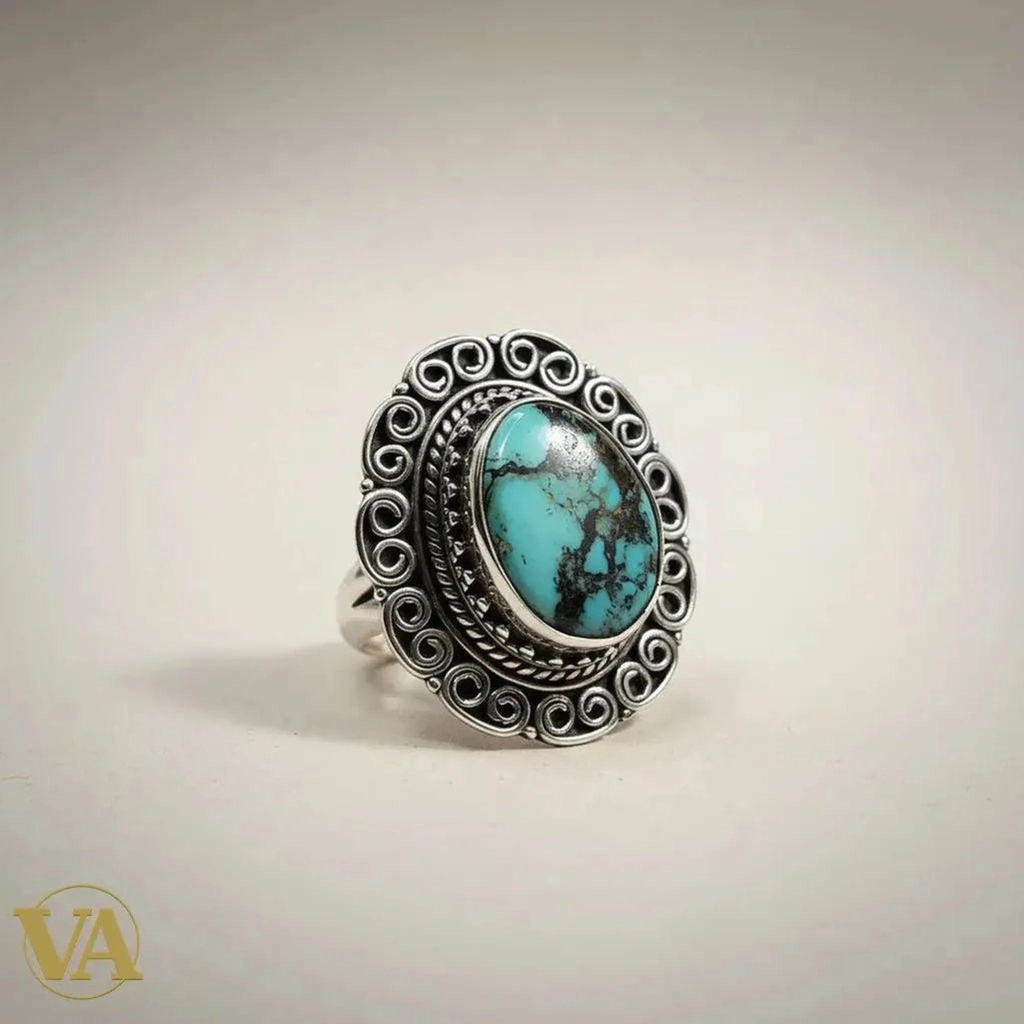 Bague femme Vindicta en argent 925 avec un cabochon turquoise ovale aux veines naturelles, serti travaillé et décor ciselé en volutes. Style bohème chic.