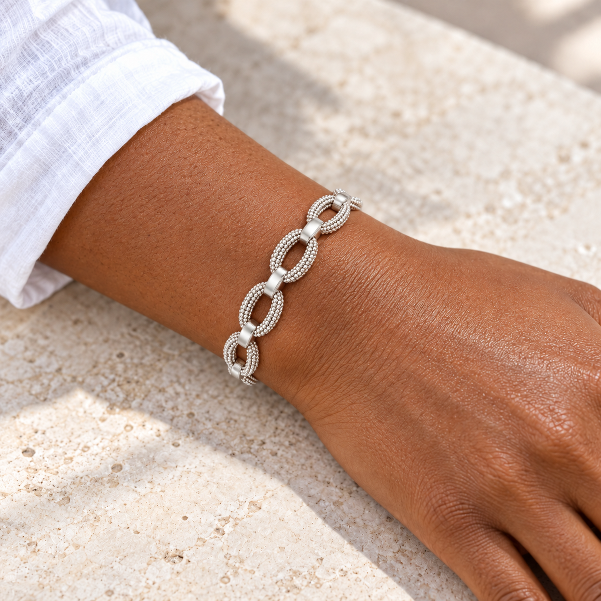 Bracelet à maillons ovales grainés — poignet peau foncée