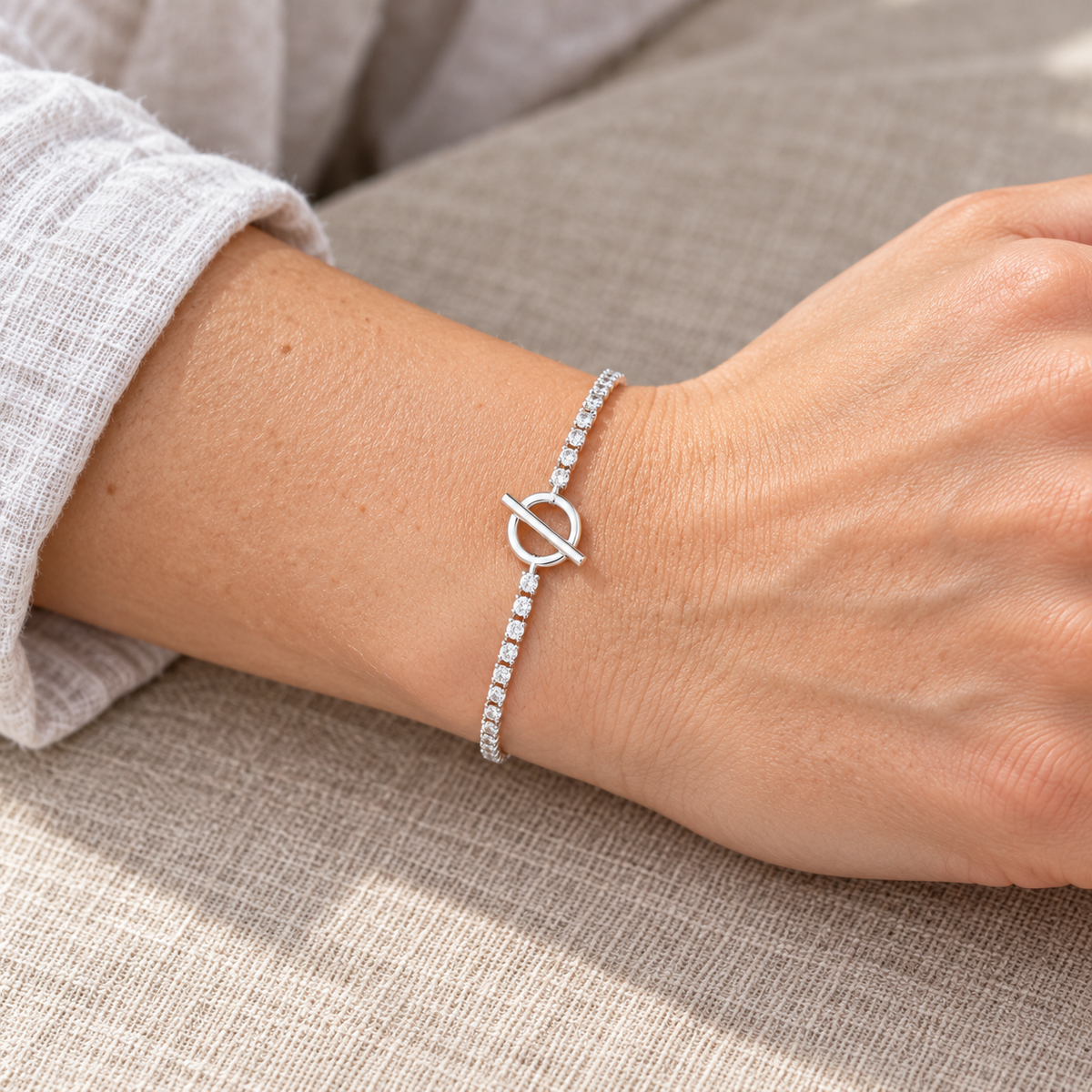 Bracelet rivière à anneau et barre — poignet de femme à peau claire, sans visage