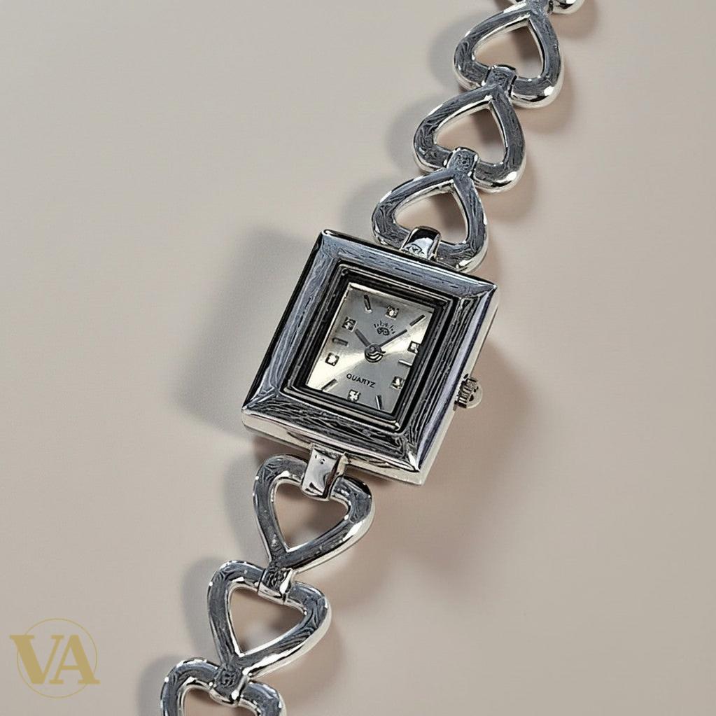 Montre Vindicta en argent 925 massif, cadran carré argenté, bracelet maillons cœurs, mouvement quartz.
