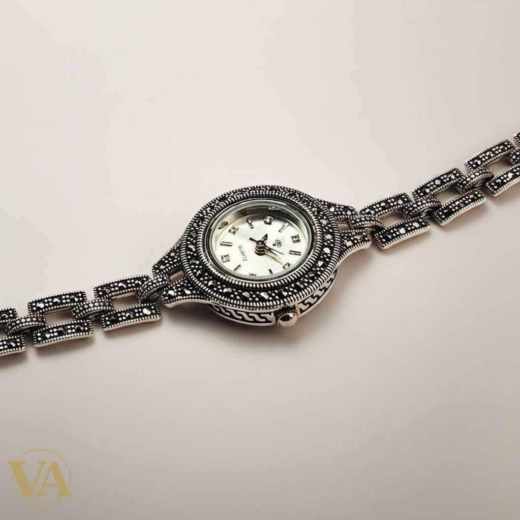Bracelet-montre Vindicta en argent 925 orné de marcassites, cadran blanc, style vintage chic.