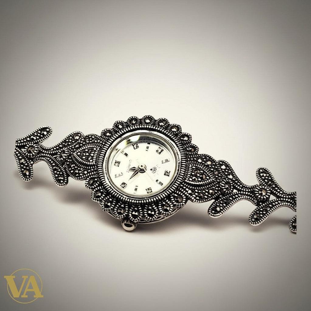 Bracelet-montre Vindicta en argent 925 ajouré avec marcassites, cadran blanc, style vintage chic.
